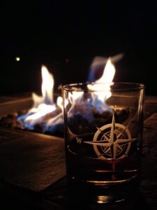 fire_drink_square Glass of whiskey in front of a fire.